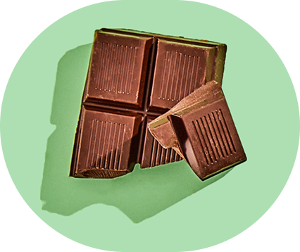 A broken chocolate bar on a green background.